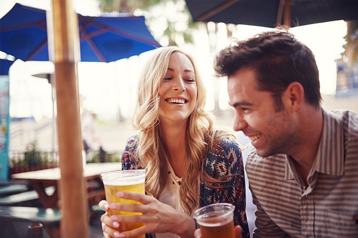 Couple enjoying beer at outdoor beer garden.