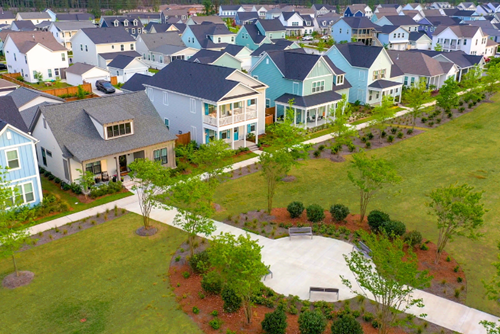 Row of modern homes with porches facing a shared green space in the Nexton community in Summerville